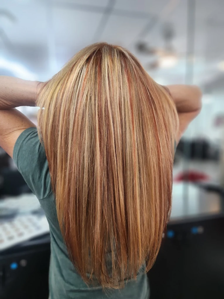 Long straight hair with blonde and copper-toned highlights and layers